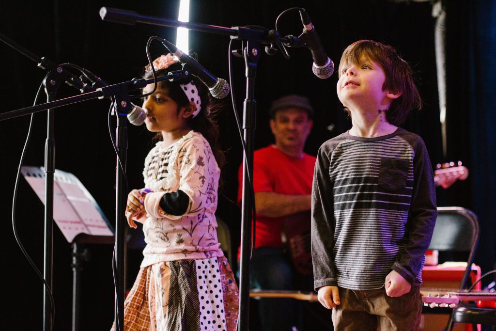 kid singing in a concert on stage