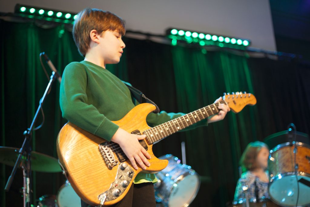 Young boy playing electric guitar